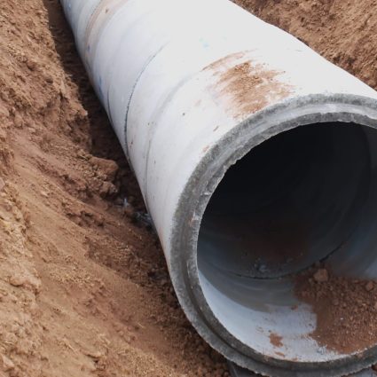 Grey pipeline in dirt in the ground