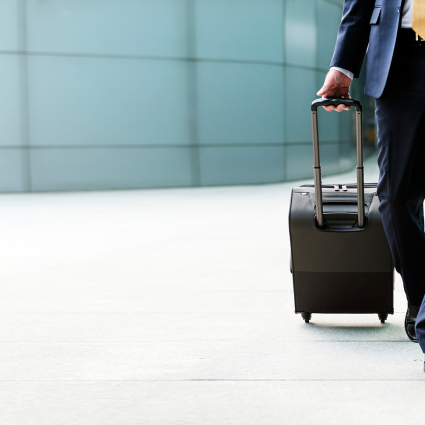 Person in a suit pulling along case